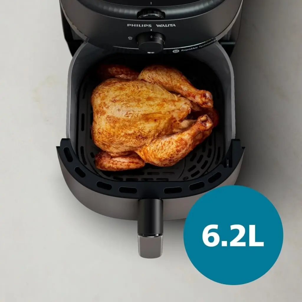 Visão superior do cesto aberto da Airfryer Philips Walita, contendo um frango inteiro assado e dourado, com um ícone azul indicando a capacidade de 6.2L no canto inferior direito.