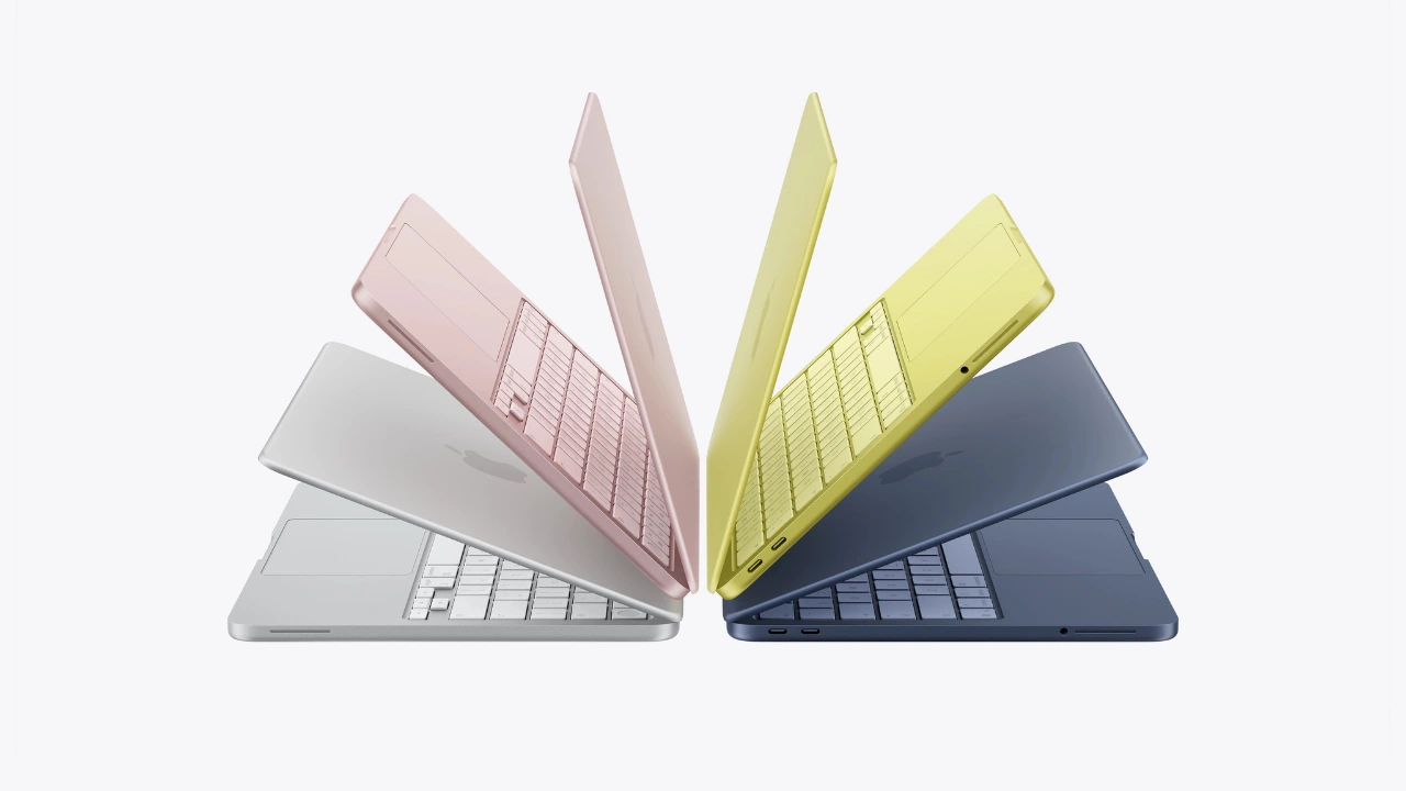Quatro notebooks MacBook Neo levemente abertos e dispostos em formato de leque, exibindo os teclados e o chassi de alumínio nas cores prateado, blush, amarelo-cítrico e índigo.