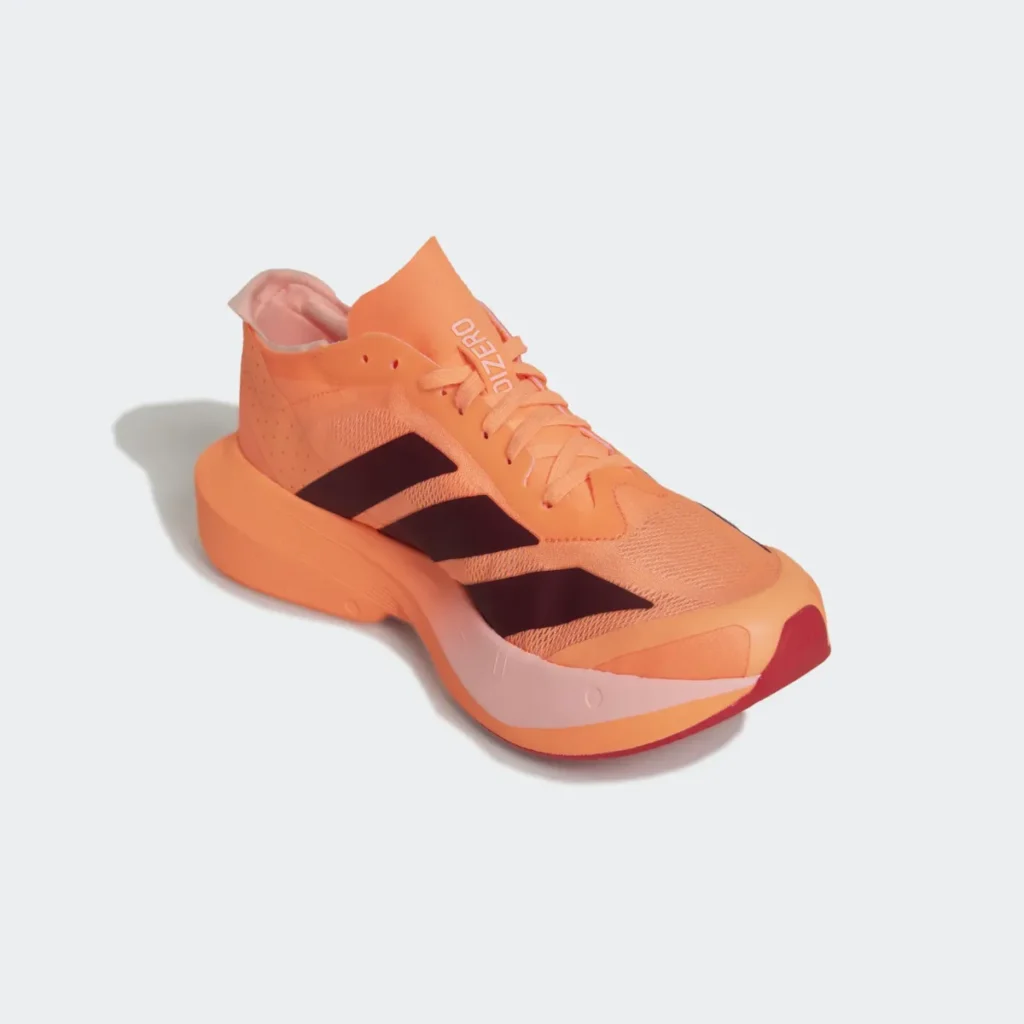 Fotografia em três quartos do tênis de corrida Adidas Adizero Drive RC Feminino na cor laranja, mostrando o cabedal de mesh, cadarços, a lingueta fina e as três listras escuras na lateral sobre fundo branco.