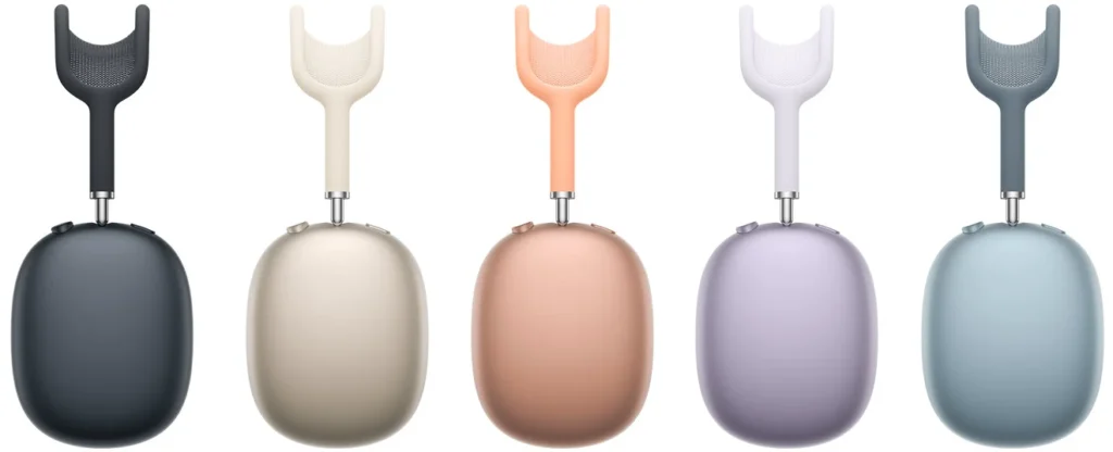 Uma imagem de estúdio em estio galeria mostrando as cinco cores da Apple para os novos fones de ouvido AirPods Max 2 em linha. Da esquerda para a direita estão: Meia-noite (cinza-escuro), Estelar (bege), Laranja (pêssego), Roxa (lavanda) e Azul (azul-celeste claro). Cada par de AirPods Max 2 está posicionado com um fone virado para a frente e o outro para cima, isolado em um fundo branco.