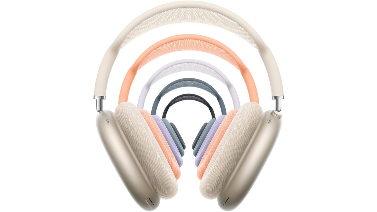 Uma imagem de estúdio empilhada mostrando cinco novas cores para os fones de ouvido AirPods Max 2 da Apple. O modelo de cor creme está na frente, com versões em laranja, branco, roxo, azul e preto aninhadas atrás.