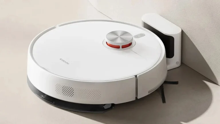 Fotografia de um robô aspirador Xiaomi na cor branca posicionado sobre um fundo claro, mostrando a visão frontal do aparelho.