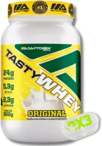 Pote branco com tampa e rótulo amarelos do suplemento Adaptogen Science Tasty Whey sabor Original (900g), classificado entre os melhores whey protein em 2026. A embalagem destaca o selo de "melhor sabor do mercado", a oferta de 24g de proteína, 5,3g de BCAA e 2,3g de leucina, além de estar acompanhada por um pequeno porta-cápsulas branco ao lado.