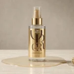 Close centralizado do frasco de Wella Professionals Oil Reflections em um ambiente de iluminação suave e fundo neutro.